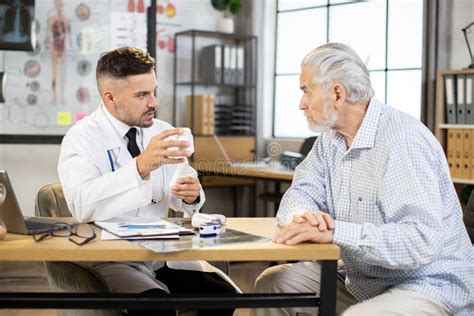 Male Doctor Providing Medical Consultation To Senior Man Stock Image