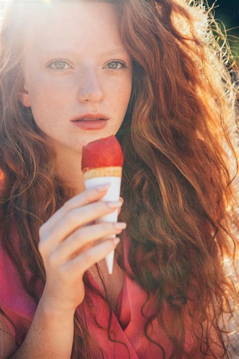 Beautiful Redhead Eating Raspberry Ice Cream By Stocksy Contributor