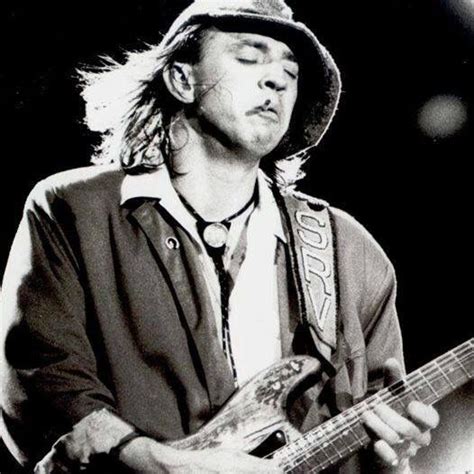 A Black And White Photo Of A Man Playing An Electric Guitar With His
