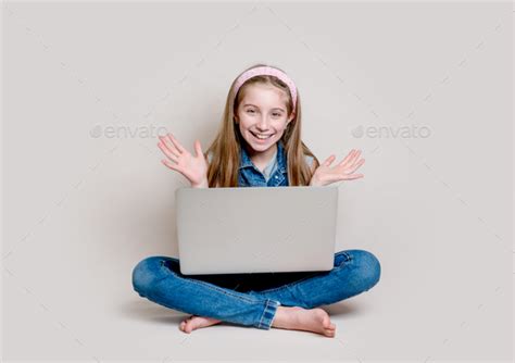 Cheerful Little Girl Sitting On The Floor With Laptop Stock Photo By