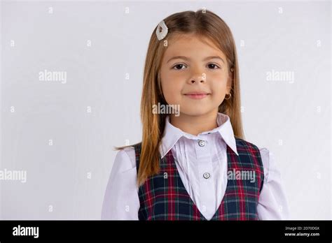 Primary School Girl Wearing Uniform Looking At Camera Isolated On White