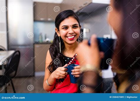 Two Indian Women Enjoying Masala Tea Together In Living Room Stock Image Image Of Home