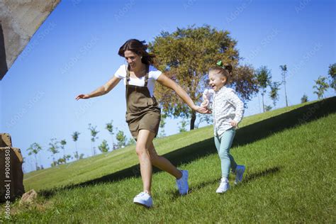 Stockfoto Una Niña Y Su Mama Corriendo Por El Parque Madre E Hija