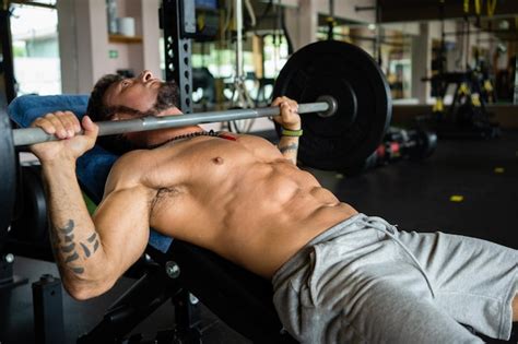 Premium Photo Fit Man Doing Bench Press Exercises In A Gym