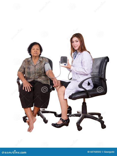 Female Doctor Measuring Blood Pressure Of Senior Woman Stock Photo