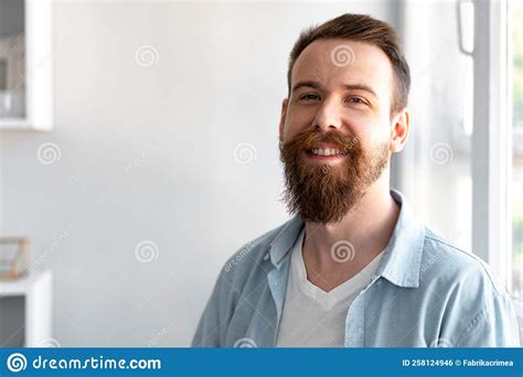 Bearded Smiling Handsome Young Man Standing Alone At Home Stock Photo