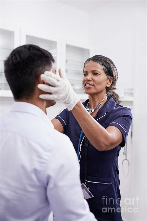 female doctor examining male patient photograph by caia image science photo library