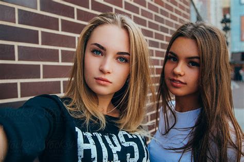 Two Young Girls Taking Selfie Using Smartphone By Danil Nevsky