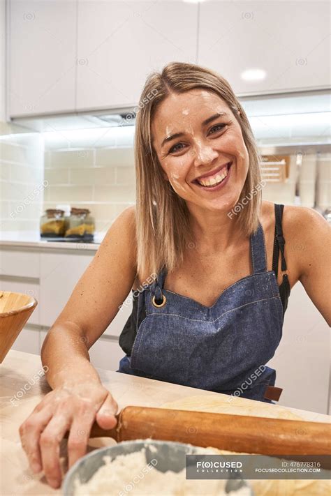 Close Up Of Smiling Woman With Flour On Face Holding Rolling Pin Over Table In Kitchen Home