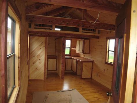 This budget friendly lofted cabin shed cabin lets you store your camping gear or workshop items in the loft with your motorycle and lawn mower in the main space. Trophy Amish Cabins, LLC - COTTAGEOPTIONAL ITEMS IN RED TEXT﻿﻿