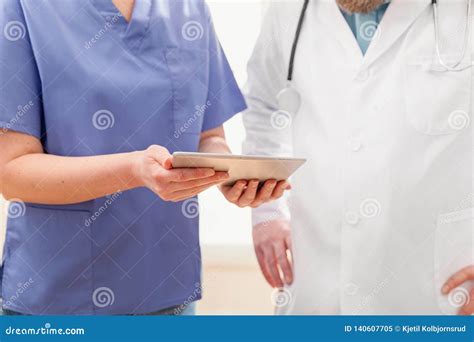 doctors discussing report about a patient at tablet computer in hospital stock image image of