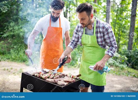 Men Friends Cooking Meat On Barbecue Grill At Outdoor Summer Party