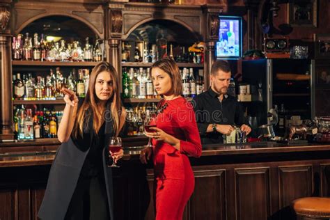 Two Female Friends Are In The Bar For A Drink And Talk The Woman With