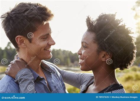 Happy Mixed Race Couple Embracing In The Countryside Stock Image