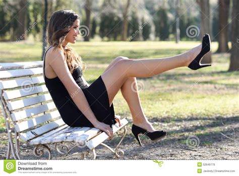 Funny Female Model Of Fashion With High Heels Sitting On A Bench Stock