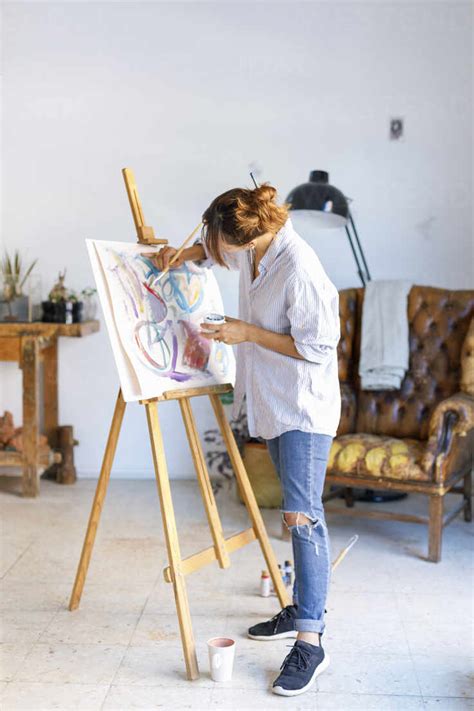 Young Female Artist Painting On Canvas In Art Studio Stock Photo