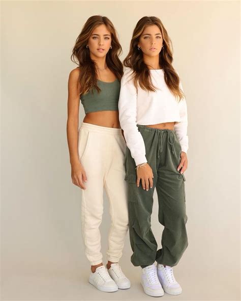 Two Women Standing Next To Each Other In White And Green Outfits One