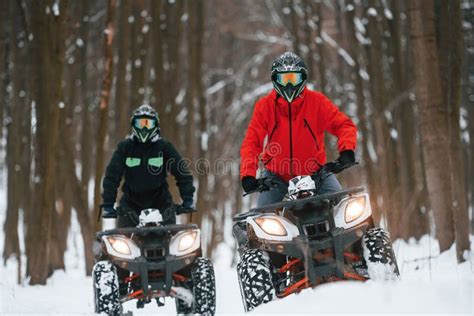 Front View Two People Are Riding Atv In The Winter Forest Stock Image