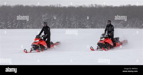 Eben Junction Michigan Snowmobiles Race Across A Snow Covered Farm