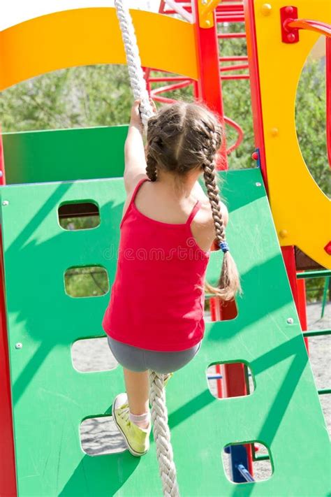 kleines mädchen das auf dem spielplatz die wand auf seil kletternd spielt stockfoto bild von