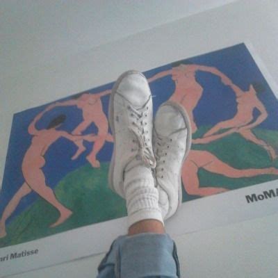 A Person S Feet With White Tennis Shoes On In Front Of A Colorful Painting