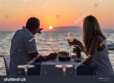 Couple Drinking Wine At Sea Beach Restaurant At Sunset Stock Photo