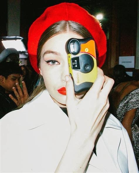 A Woman In A Red Beret Holding Up A Cell Phone To Her Face