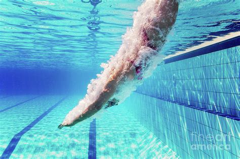 swimmer diving into pool photograph by microgen images science photo library fine art america