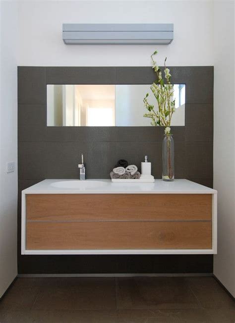 A floating vanity table with extra storage space for all your makeup is a nice way to utilize an empty nook. DIY Floating Wooden Bathroom Vanity Against Dark Gray Wall ...