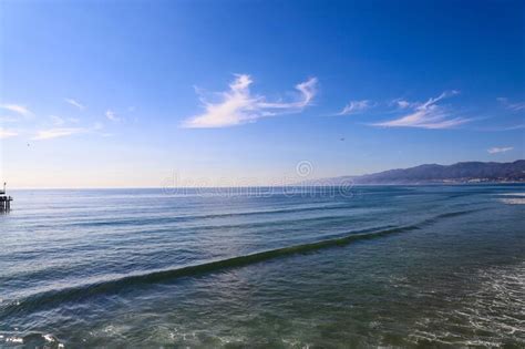 A Majestic Shot Of The Large Waves Breaking In Vast Blue Ocean Water With Blue Sky And Clouds