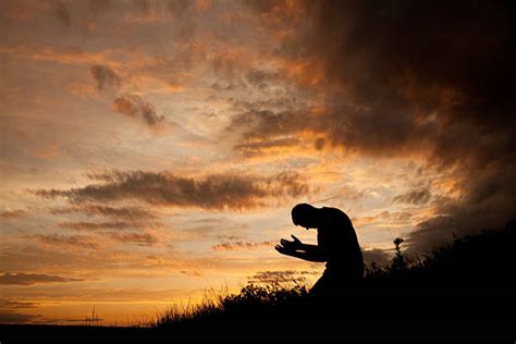 Evening Prayer Silhouette Of Unrecognizable Man Kneeling Stock Photos