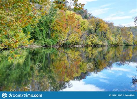 Water Reflections Of Colored Trees Under A Blue Sky Stock Image
