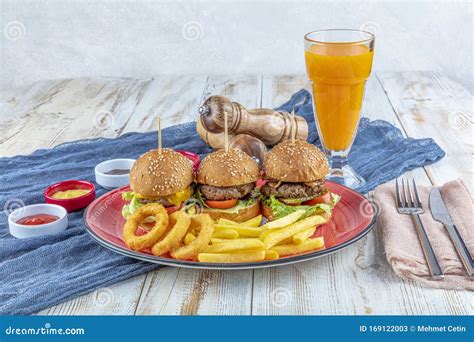 Three Different Burger With Pickles Onion Rings And French Fries On Red