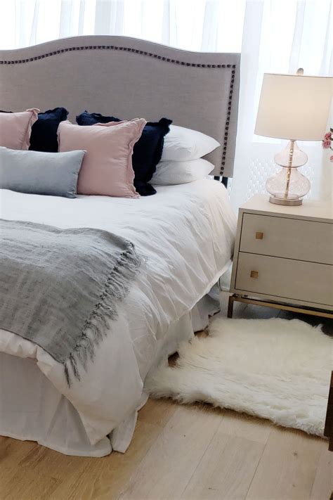 An airy living room with white tiled flooring and suspended ceiling. Cool bedroom design in NYC apartment with pink and grey color scheme and sheepskin rug | Bedroom ...