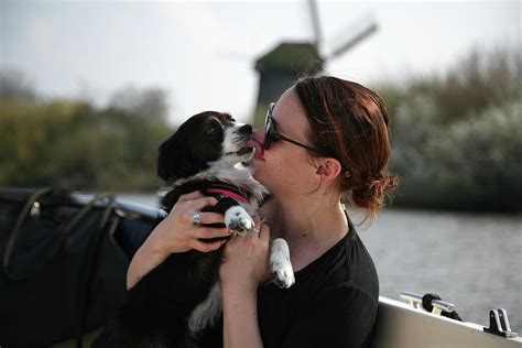 A Young Woman Getting Licked By Her Dog On A Boat Ride Photograph By