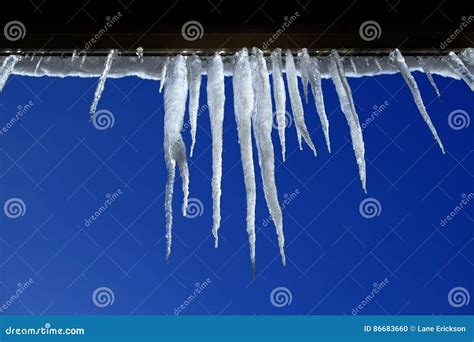 Icicles Hanging From Rooftop Of Home Melted Ice Dripping Stock Photo