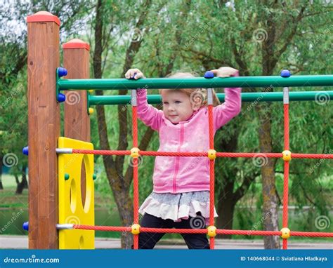 A Little Girl Learns To Climb Ladders And Crossbars Stock Photo Image