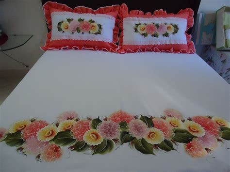 A White Bed With Pink And Yellow Flowers On It