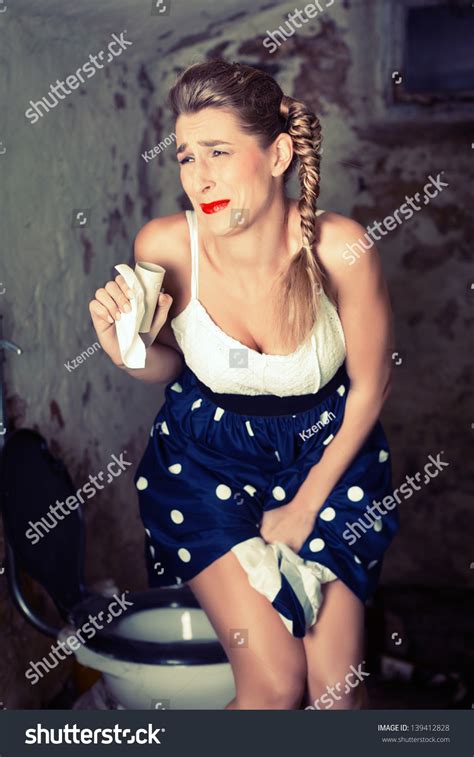 Woman Peeing On The Shabby Toilet With Not Bathroom Paper Stock Photo
