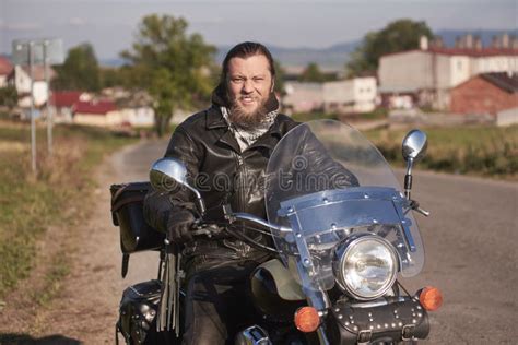 Portrait Of Biker Man With Beard Sitting On His Motorcycle Stock Photo