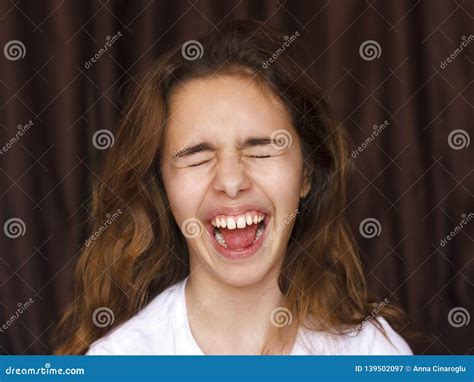 Pretty Teenager Girl With Long Hair Makes Very Funny Face And Laughing