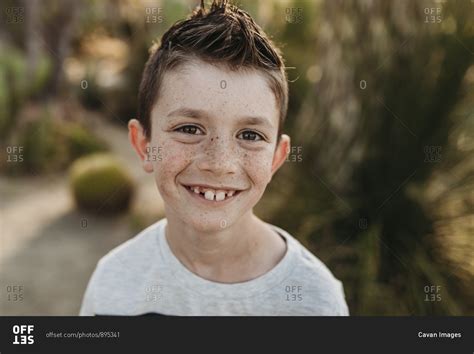 Close Up Portrait Of Cute Young Boy With Freckles Smiling Stock Photo