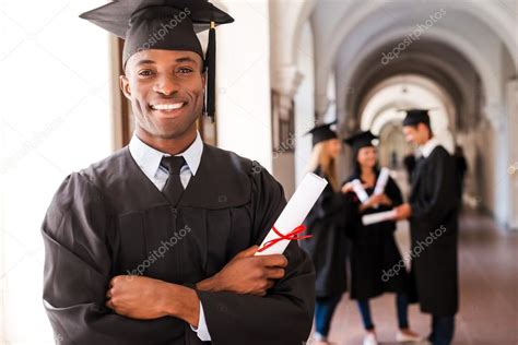 African Man In Graduation Gown Holding Diploma Stock Photo By