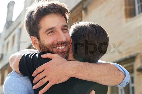Loving Male Gay Couple Hugging Outside In City Street Stock Image
