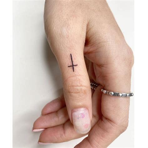 Minimalist Cross Tattoo On The Thumb