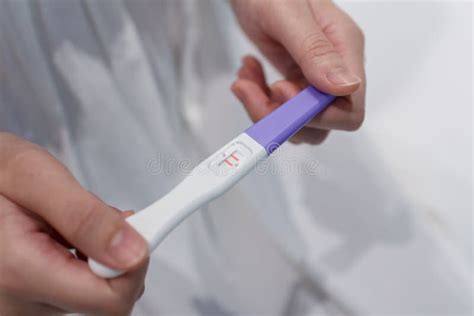 Hand Holding The Pregnancy Test Is Showing A Positive Result Stock