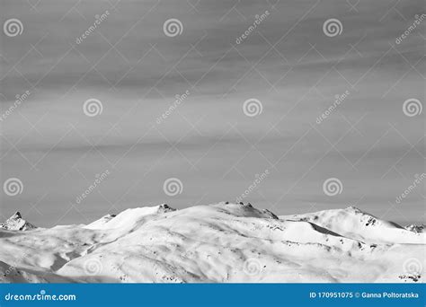 High Mountains With Snowy Slopes And Sunlit Cloudy Sky At Winter