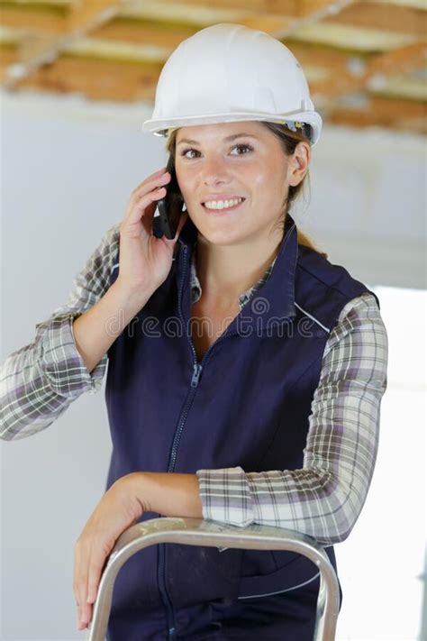 Portrait Female Builder On Stepladder Taking Telephone Call Stock Image