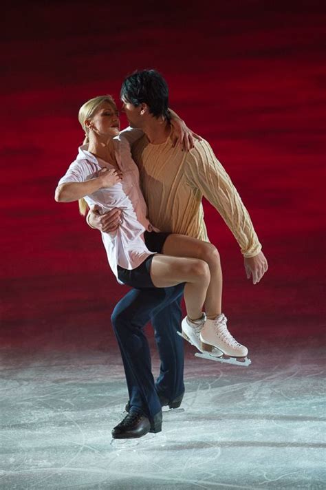 a man and woman skating on ice in front of a red background at the same time