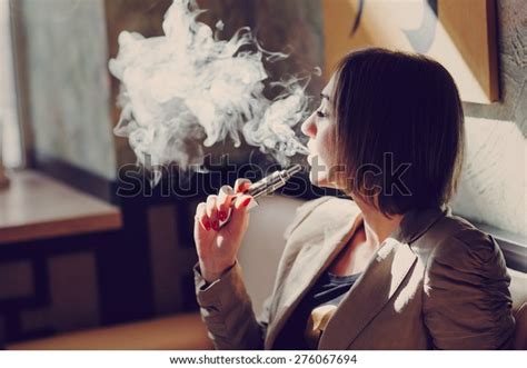 Young Woman Smoking Electronic Cigarette Stock Photo 276067694
